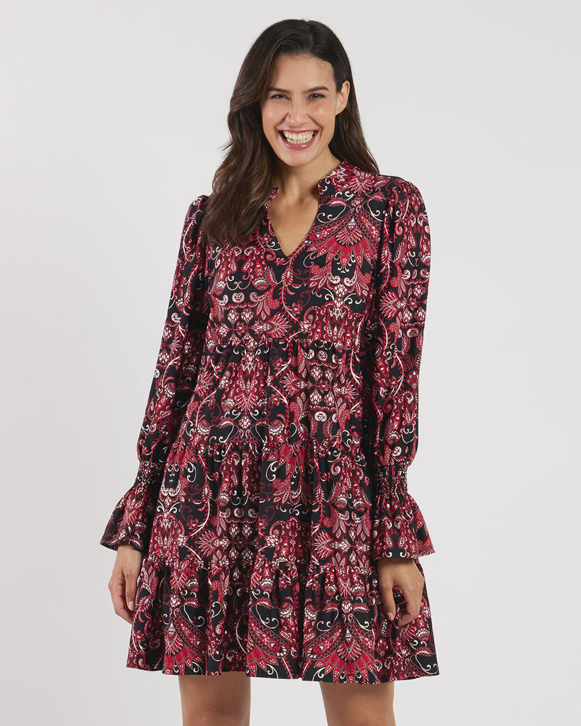 Woman wearing a patterned dress on a plain background