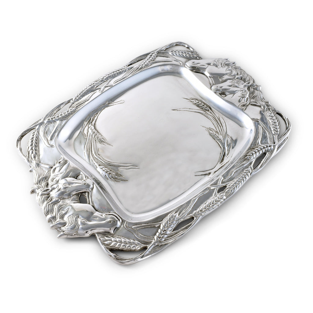 Silver decorative tray with intricate designs on a white background
