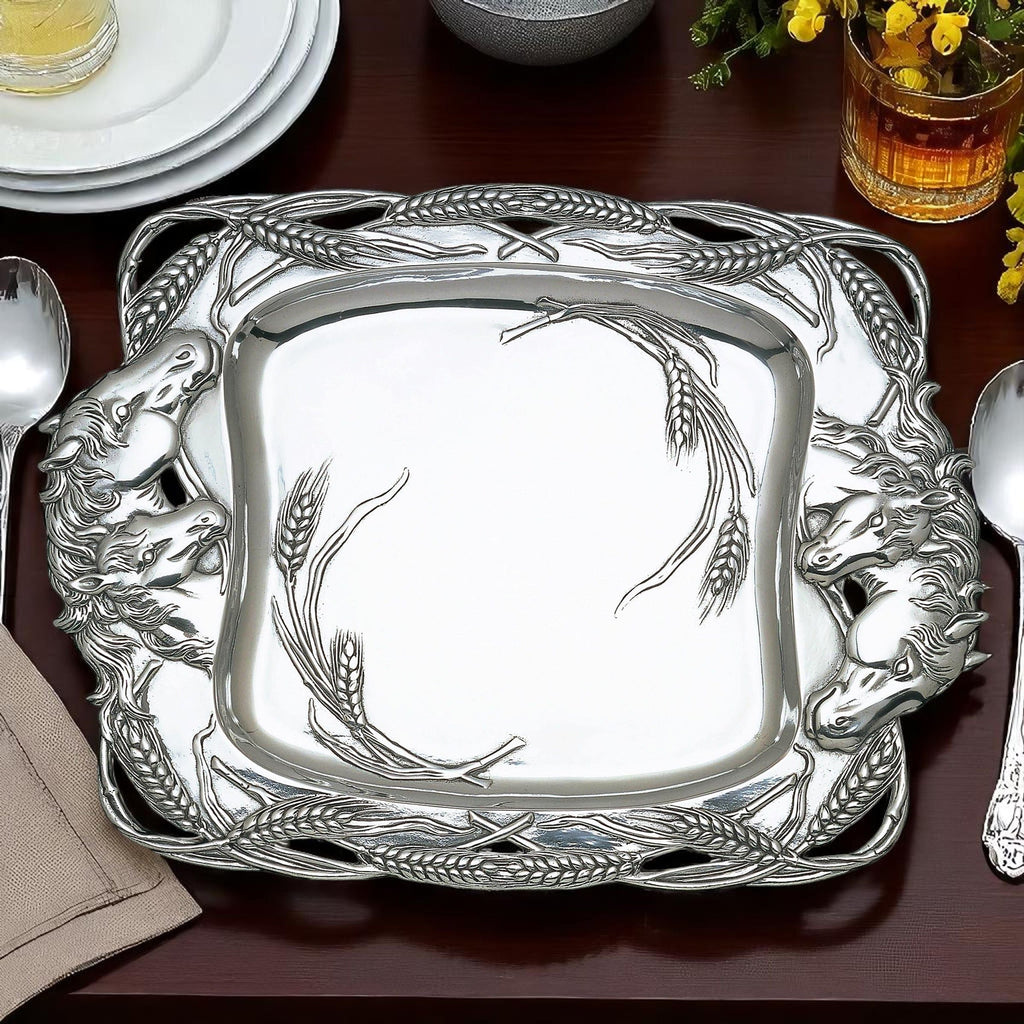 Decorative silver platter with animal designs on a table setting.