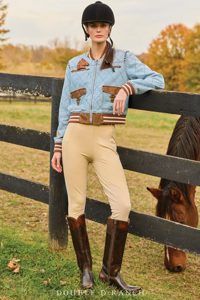Woman in equestrian attire standing next to a horse in an outdoor setting