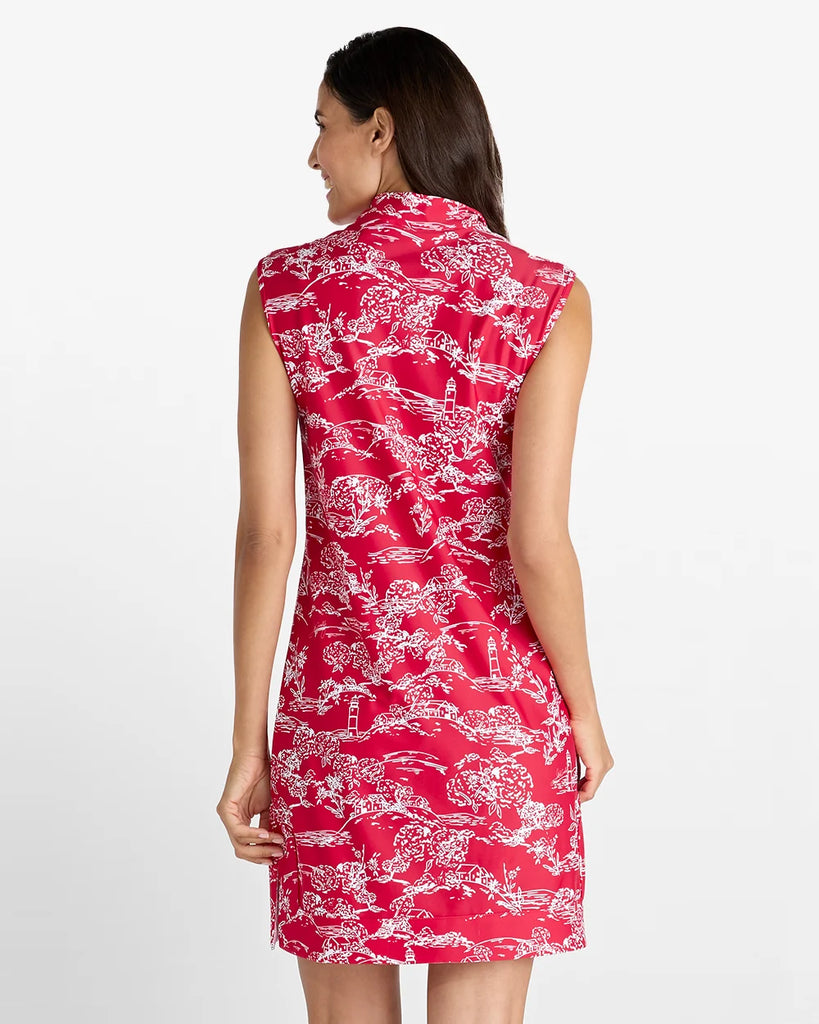 A woman shown from the back wearing a sleeveless red dress with a white toile-style print, photographed against a plain light gray studio background.