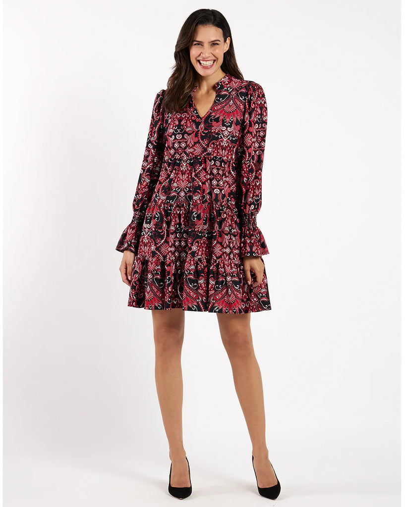 Woman wearing a patterned dress on a white background