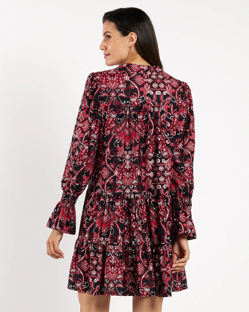 Woman wearing a red and black patterned dress on a white background