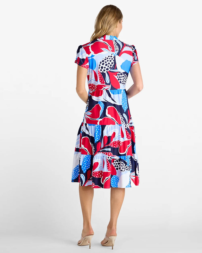 Woman wearing a colorful patterned dress on a white background