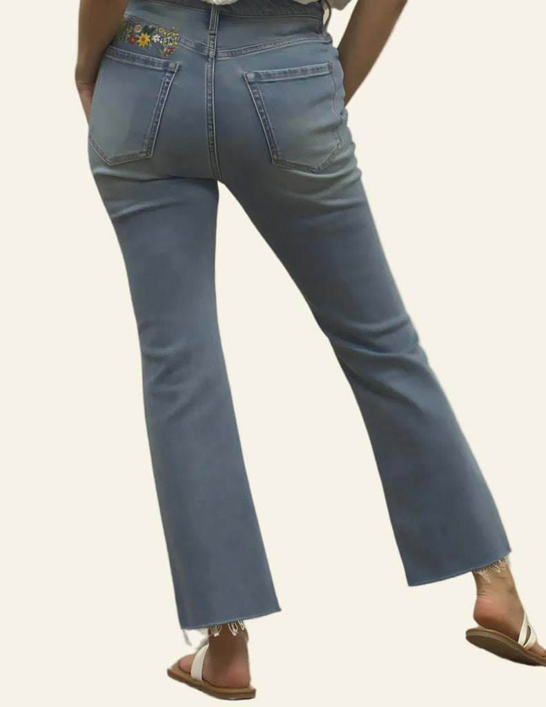 Blue retro jeans worn by a person on a plain background