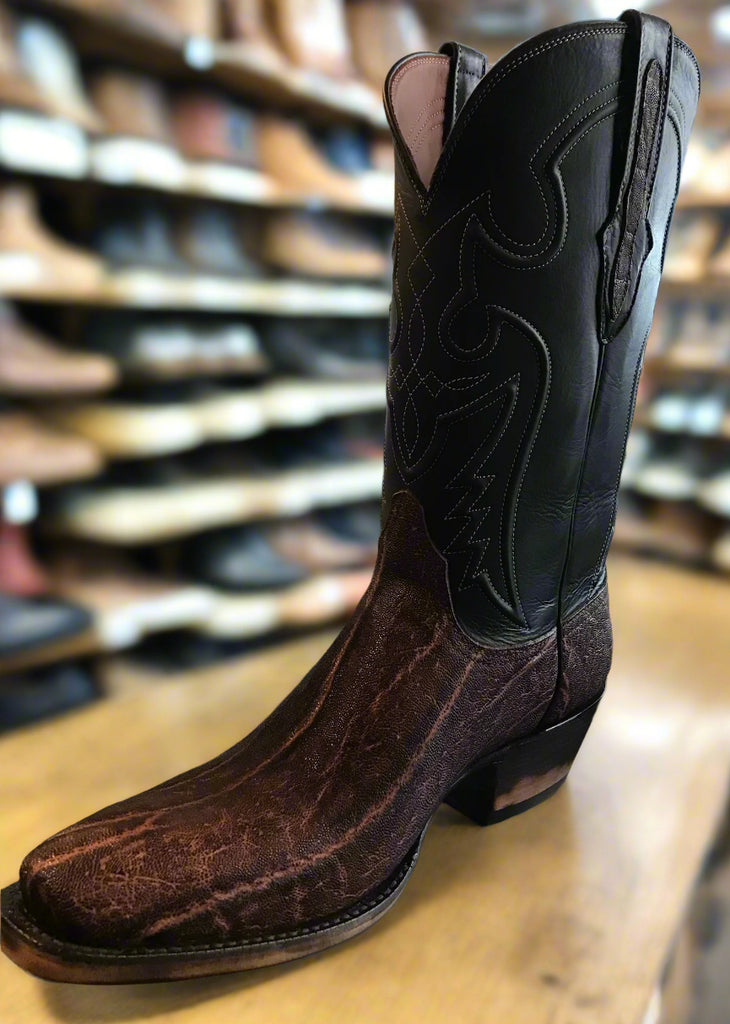 Black and brown cowboy boot on a glass surface with a store interior background