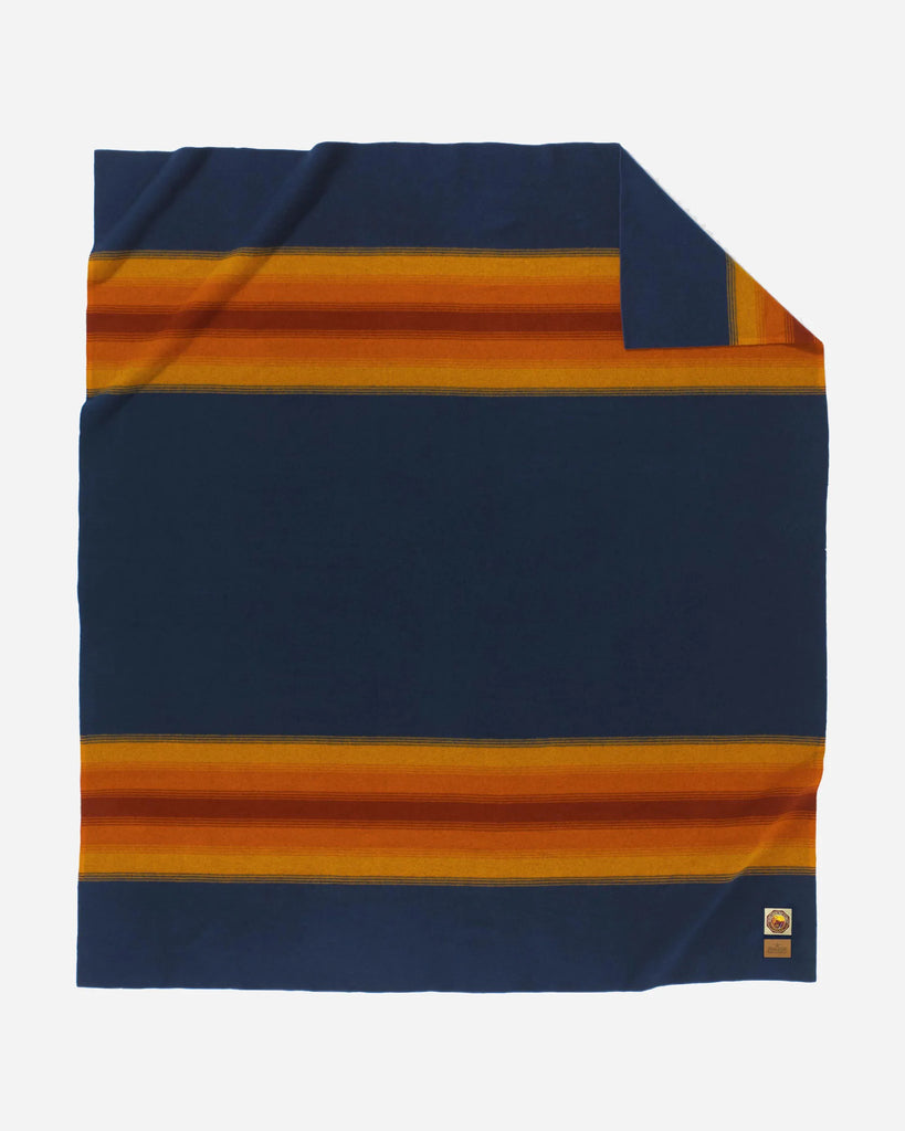 Navy blue blanket with orange and yellow stripes on a white background