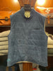 Blue puffer vest on a rack with leather bags in the background