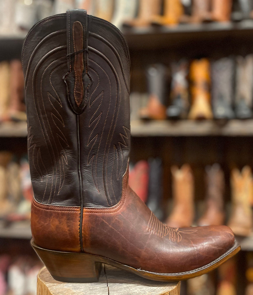 Brown Leather Buffalo Cowboy Boot in front of a boot wall filed with mens cowboy boots Black Jack Mens Cowboy Boots 