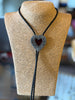 Heart-shaped bolo tie on a mannequin bust with a blurred background