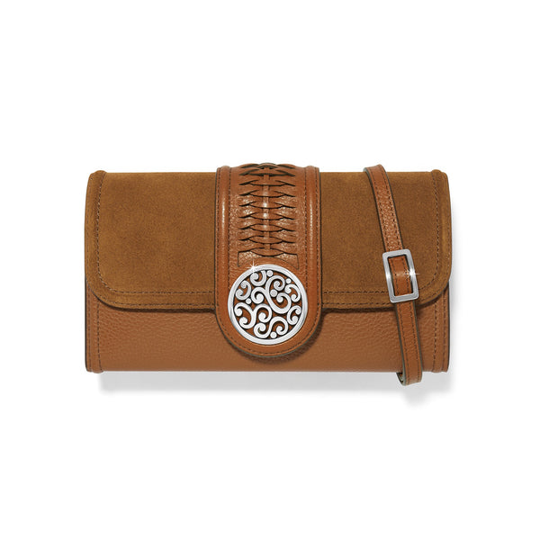 Brown leather clutch with decorative emblem and strap on a white background