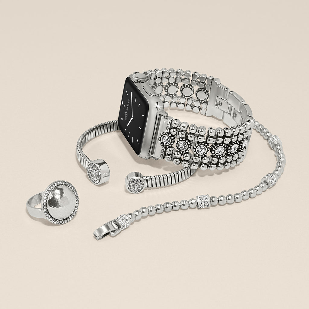 Silver smartwatch with decorative band and matching ring on a beige background