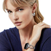 Woman wearing a bracelet and earrings on a white background