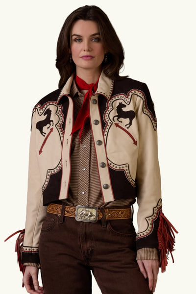 Woman wearing a western-style jacket with intricate designs on a brown background