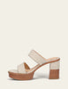 A single platform mule sandal with a chunky block heel, featuring light beige leather straps with decorative stitching and a light brown wood-grain sole and heel.