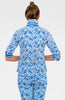 Person wearing a blue and white patterned outfit on a plain background