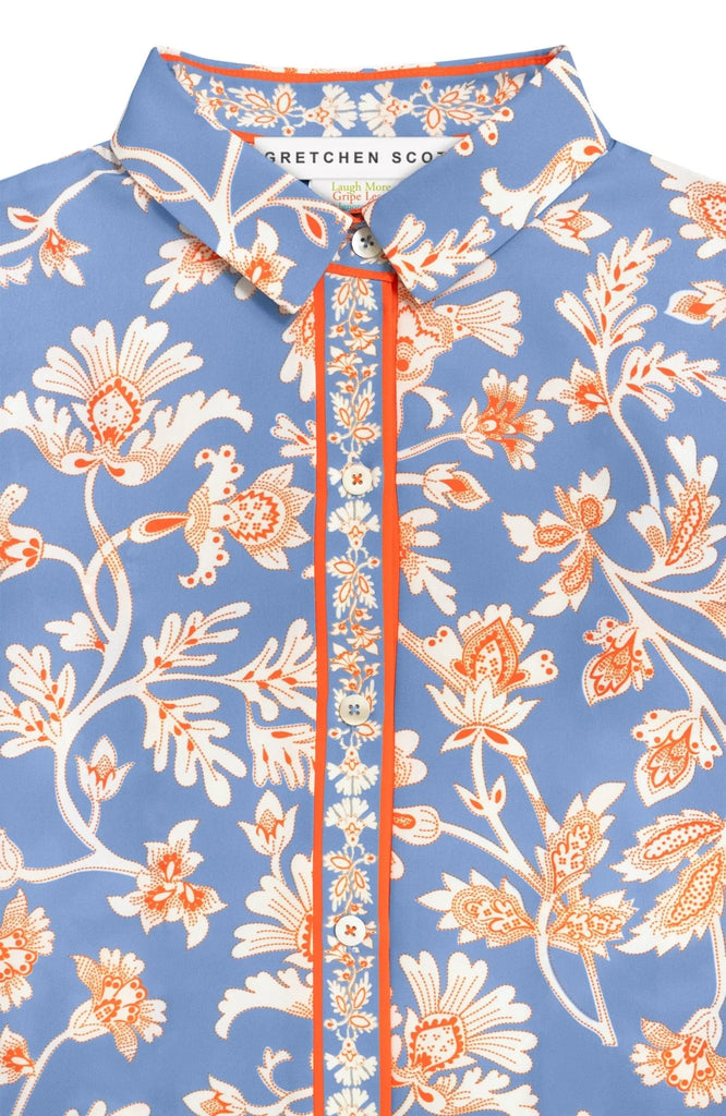 Floral patterned shirt with orange and white details on a blue background
