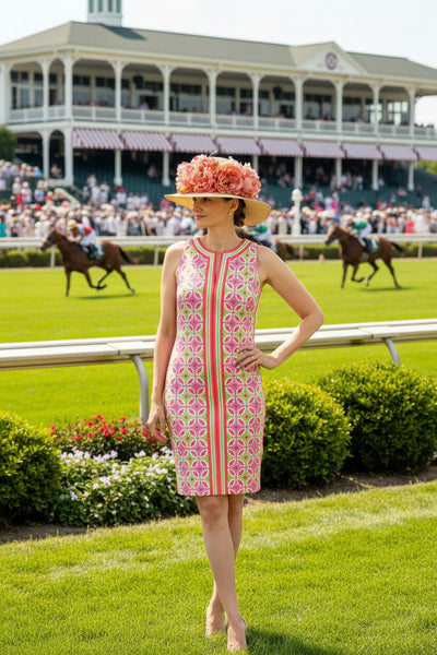 Woman wearing a colorful patterned dress and hat with flowers on a white background