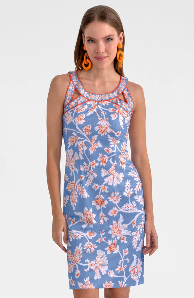 Woman wearing a blue floral dress with orange accents on a white background