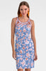 Woman wearing a blue floral dress with orange accents on a white background