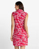 A woman shown from the back wearing a sleeveless red dress with a white toile-style print, photographed against a plain light gray studio background.
