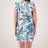 Woman wearing a floral dress with blue and green patterns on a plain background