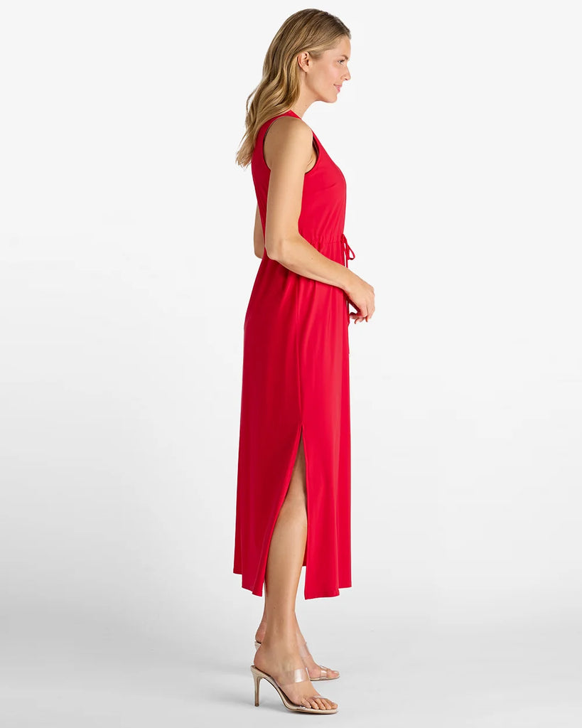 Woman wearing a red dress with a slit on a white background