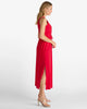 Woman wearing a red dress with a slit on a white background
