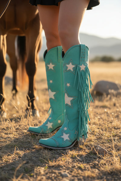 Turquoise cowboy boots with star patterns and fringes on a poolside background