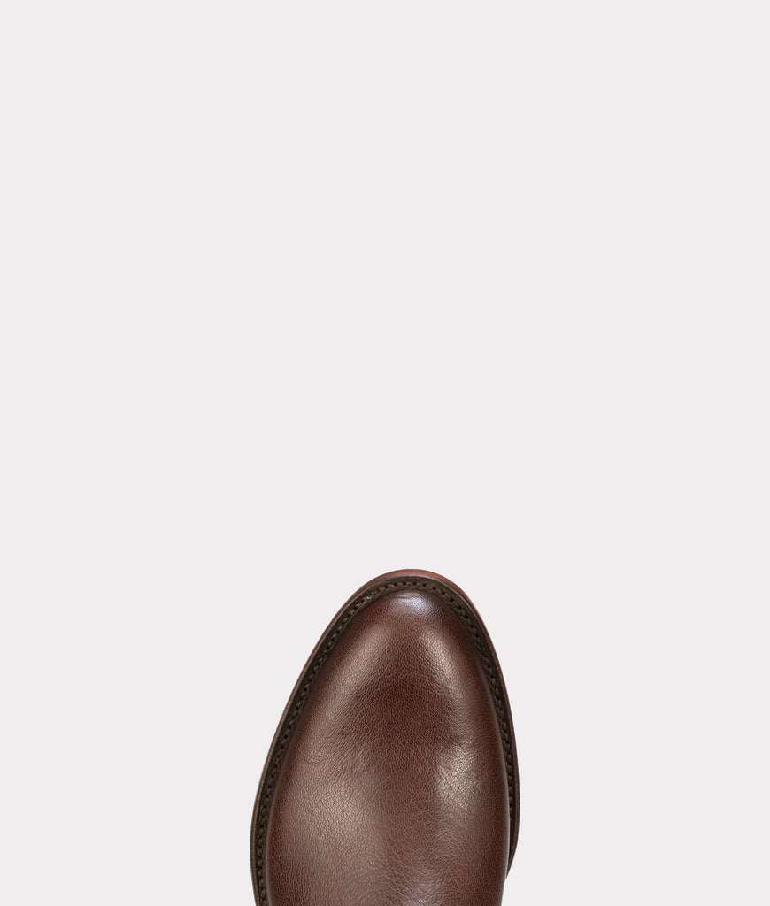 Brown Lucchese leather boot tole with leather sole on a light gray background