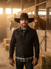 Black wide-brimmed wool hat with braided band on a wooden surface, blurred store interior background
