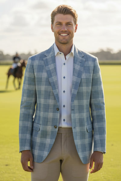 Man wearing a blue checkered blazer, white shirt, beige pants, and brown shoes on a light gray background