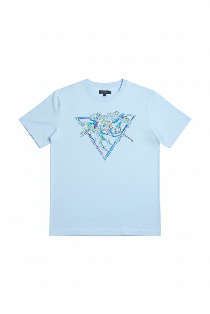 A man wearing a light blue crewneck t-shirt with a large iridescent blue and white graphic on the chest, paired with white pants, against a plain white background.