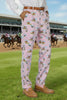 Person wearing pink patterned pants with a white shirt on a white background