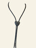 Heart-shaped pendant on a black cord displayed on a mannequin bust.