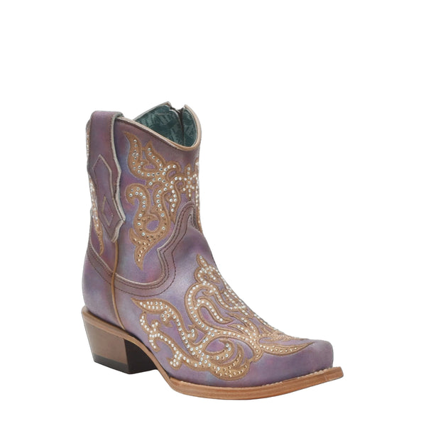 Decorative cowboy boot with intricate patterns on a black background