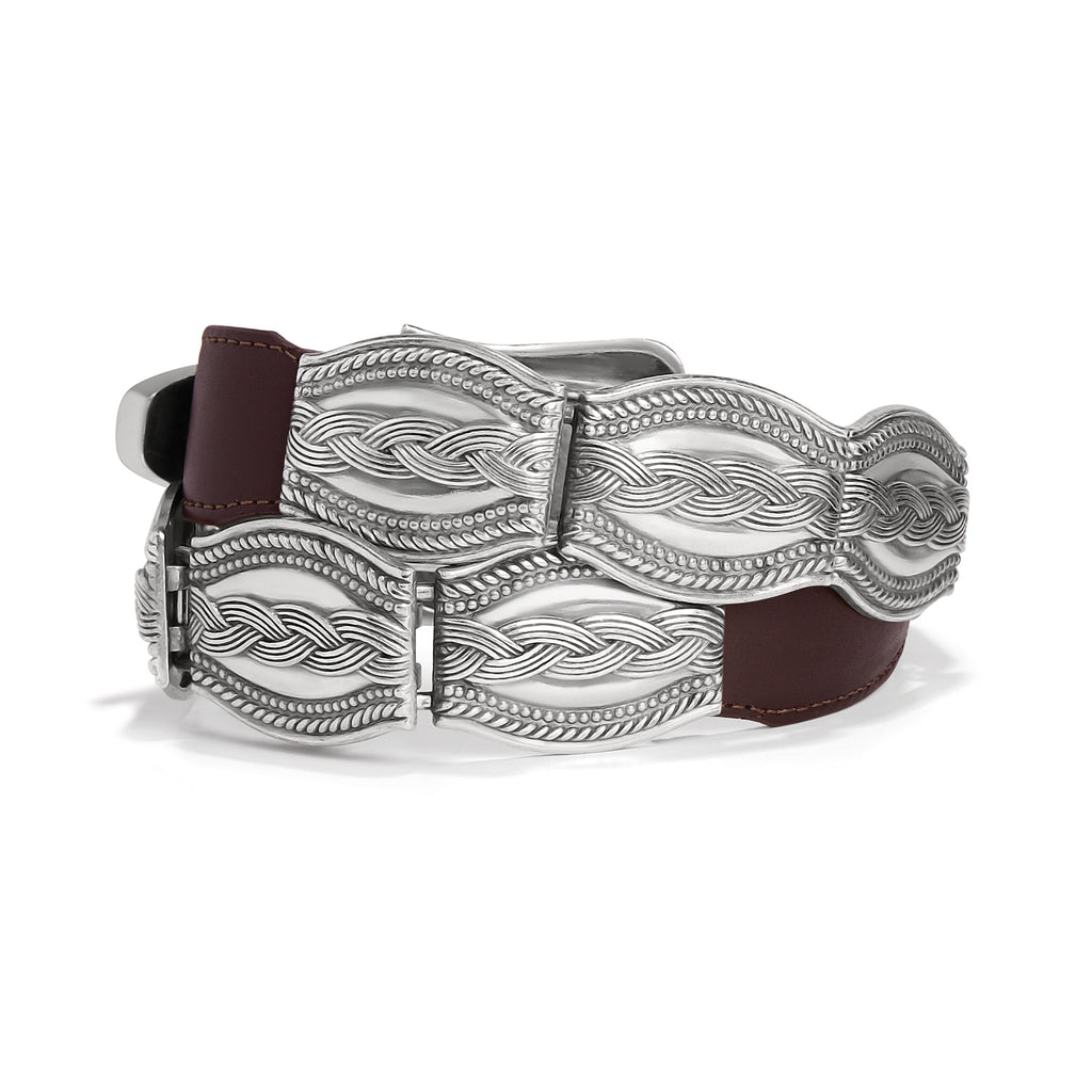Silver belt buckle with intricate designs on a white background